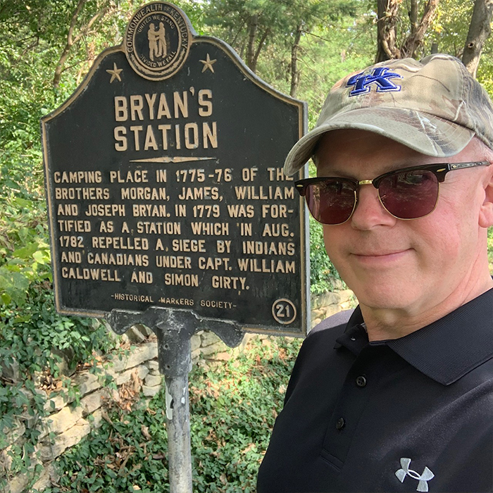 Man in front of a plaque for Bryan's Station